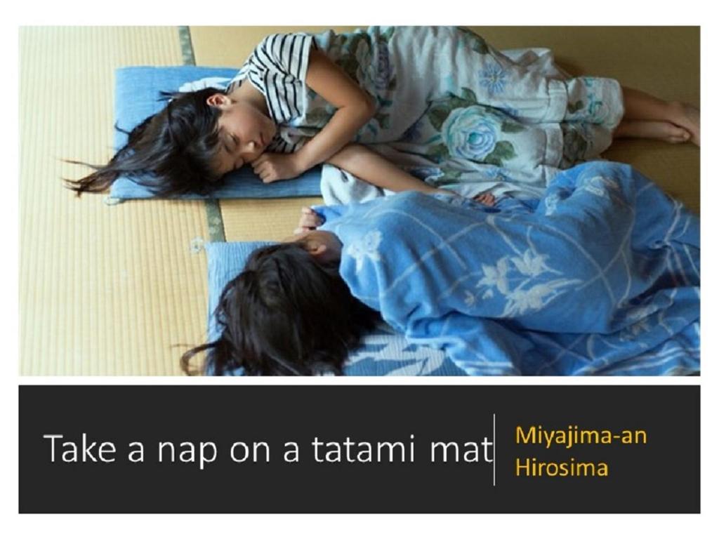 deux filles qui se reposent à même le sol sur leur lit dans l'établissement Ryokan with natural hot springs and okonomiyaki Miyajima-an Hiroshima, à Miyajima
