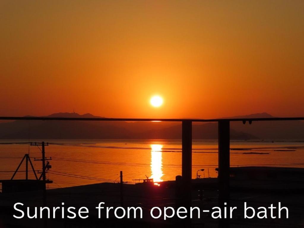 - un coucher de soleil depuis un bain en plein air dans l'océan dans l'établissement Ryokan with natural hot springs and okonomiyaki Miyajima-an Hiroshima, à Miyajima