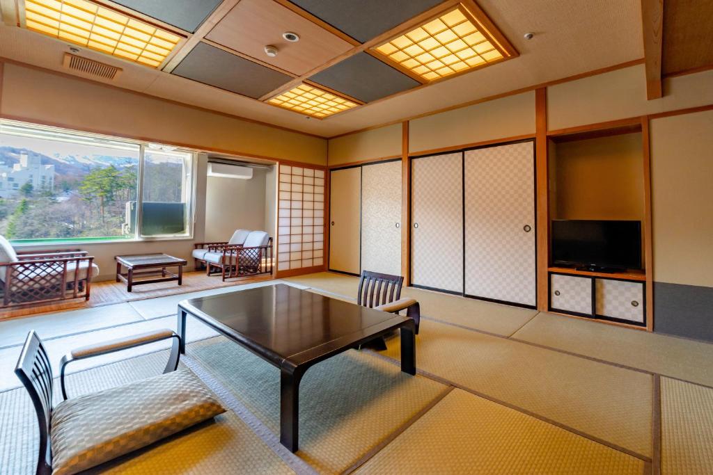un salon avec une table et des chaises dans l'établissement Daitokan, à Kusatsu