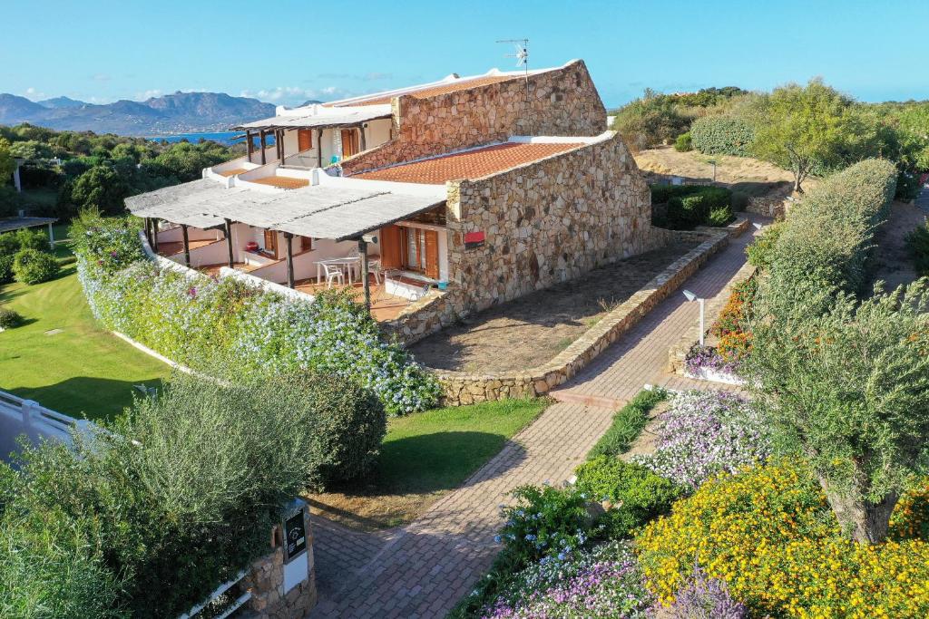 une vue extérieure d'une maison avec un mur en pierre dans l'établissement Capo Ceraso Family Resort, à Costa Corallina