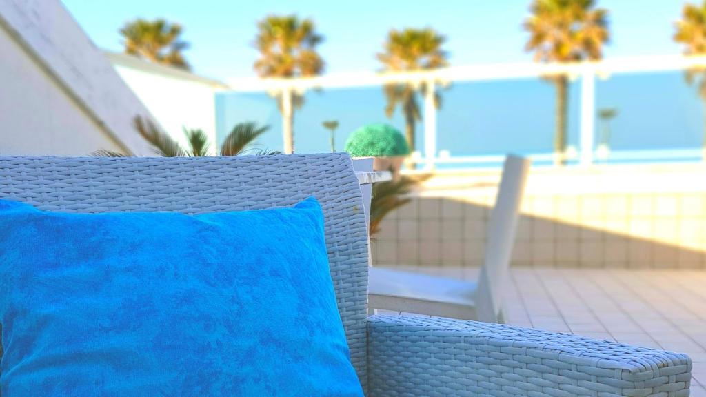 un oreiller bleu posé sur une chaise sur une terrasse dans l'établissement Martur Resort, à Termoli 77 autres photos