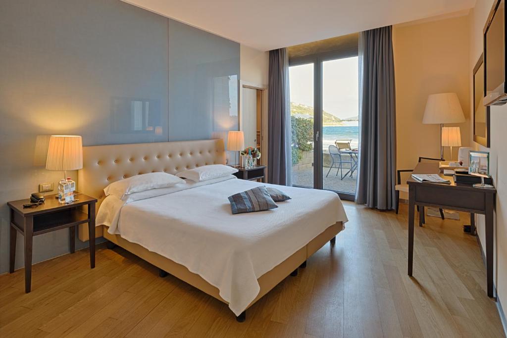 une chambre avec un grand lit et une vue sur l'océan dans l'établissement Hotel Riviera dei Fiori, à San Lorenzo al Mare