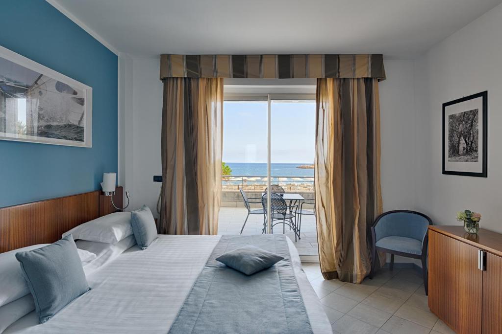 une chambre avec un lit et une vue sur l'océan dans l'établissement Aregai Marina Hotel & Residence, à Santo Stefano al Mare