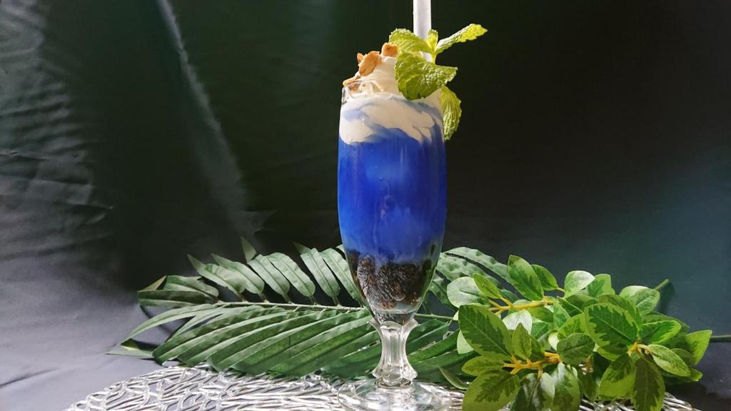 une boisson bleue posée sur une table dans l'établissement Hotel Regina, à Kashiwa