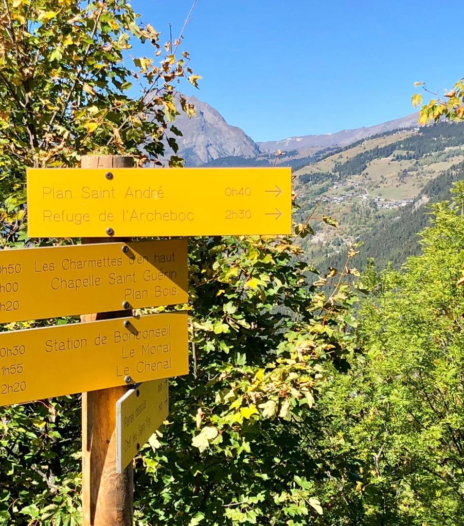 un signe jaune avec des flèches sur une montagne dans l'établissement Black Diamond Sainte Foy Chalets, à Sainte-Foy-Tarentaise