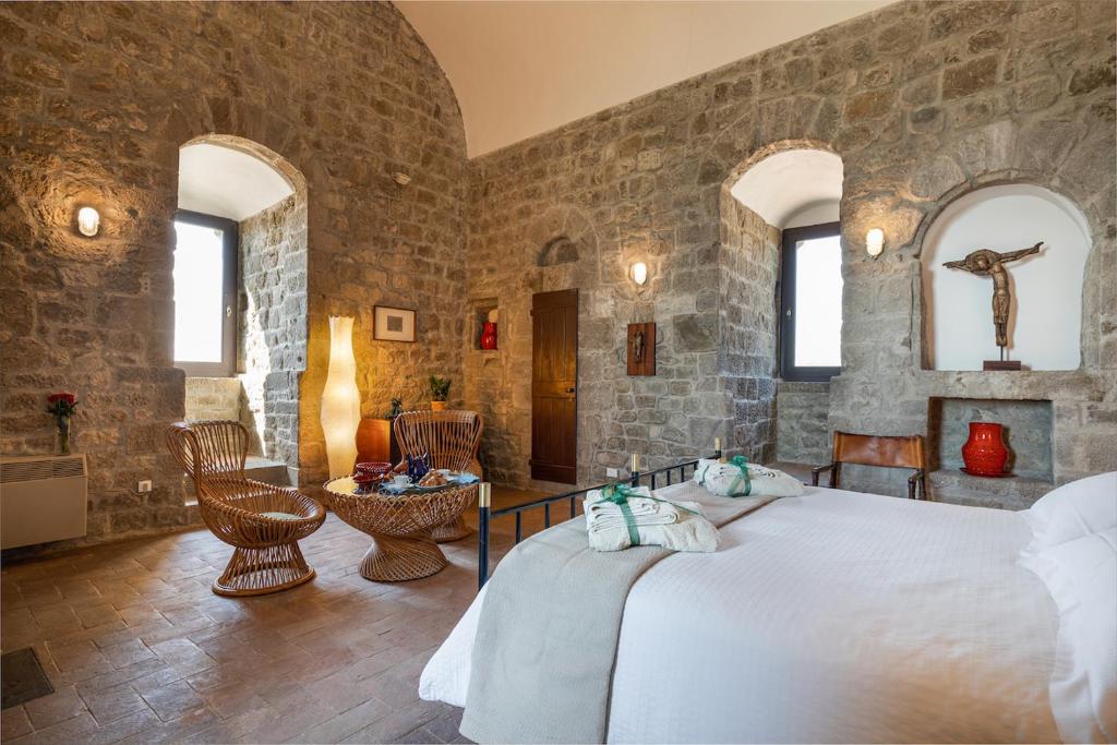 une chambre avec un grand lit dans un mur de pierre dans l'établissement Torre dei Belforti, à Montecatini Val di Cecina 73 autres photos