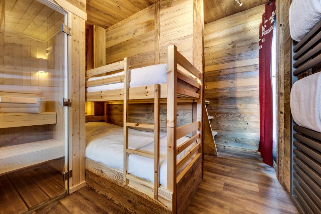 - une chambre avec des lits superposés dans une cabane en rondins dans l'établissement Appartement d'exception Tignes, à Tignes