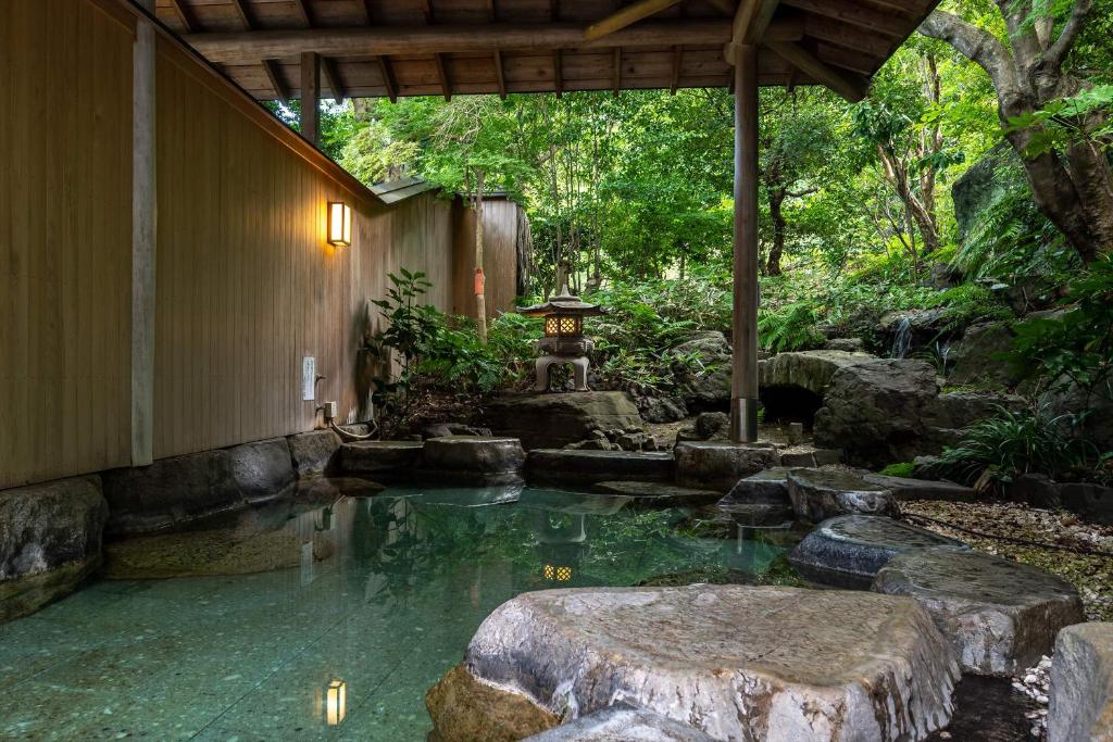 - un jardin avec un étang au milieu d'une maison dans l'établissement Senpokaku, à Toba