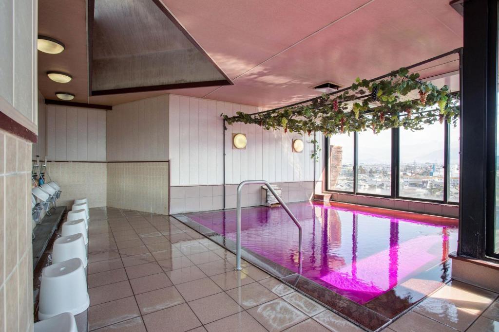 d'une salle de bains avec une piscine et des fenêtres. dans l'établissement Hotel Hatta, à Fuefuki