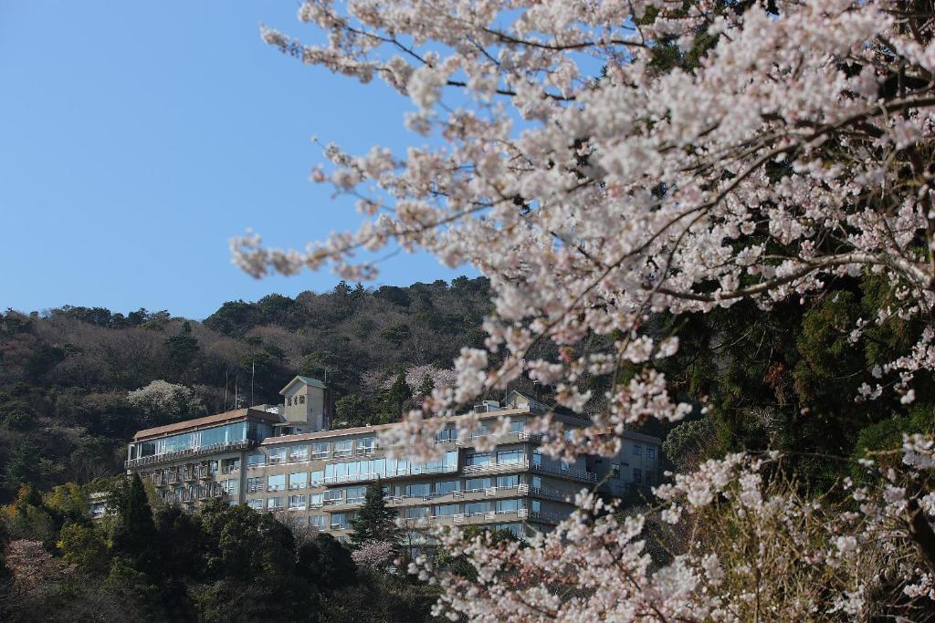 un bâtiment sur une colline avec des akura au premier plan dans l'établissement Senpokaku, à Toba