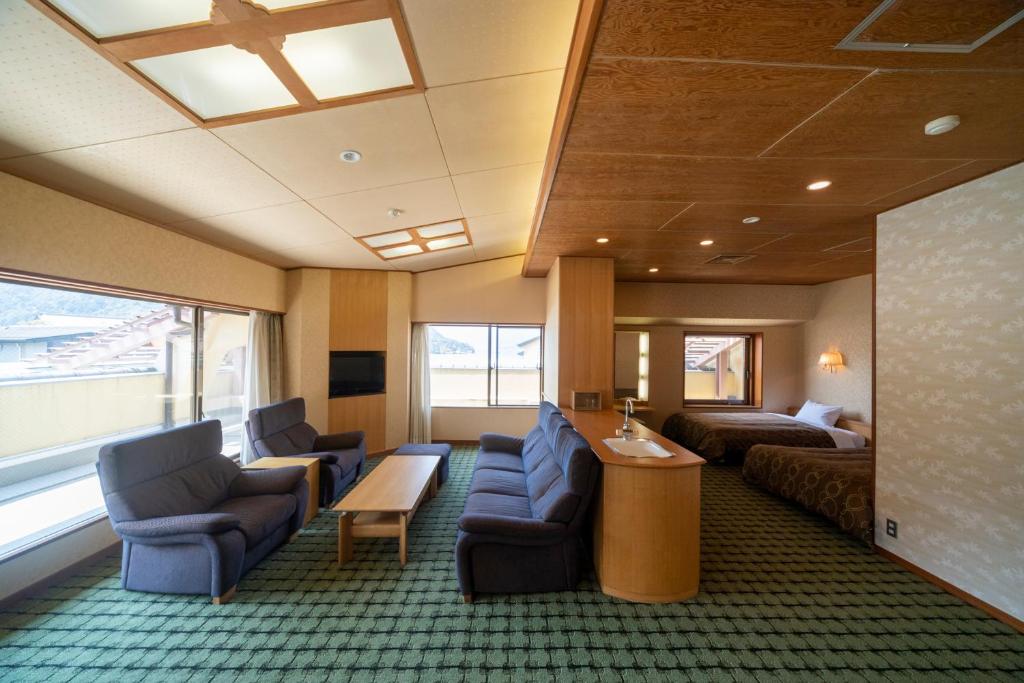 une chambre d'hôtel avec un lit et un salon dans l'établissement Hotel Miya Rikyu, à Miyajima