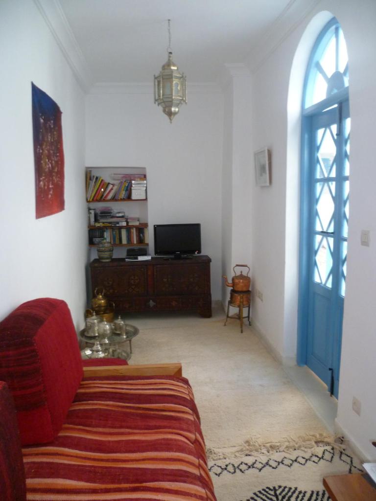 - un salon avec un canapé rouge et une porte bleue dans l'établissement Dar Daoud, à Marrakech