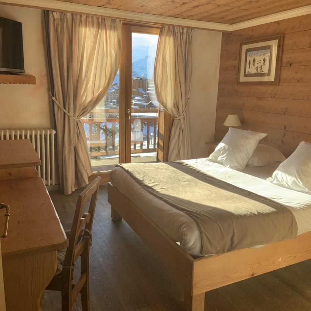 une chambre avec un lit et une grande fenêtre dans l'établissement Alp'azur, à L'Alpe-d'Huez