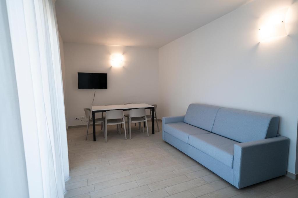 un salon avec un canapé bleu et une table dans l'établissement Sabbia & Mare, à Rosolina Mare