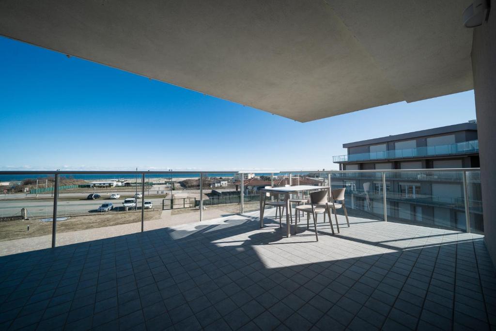 un balcon avec une table et des chaises et une vue sur la plage dans l'établissement Sabbia & Mare, à Rosolina Mare