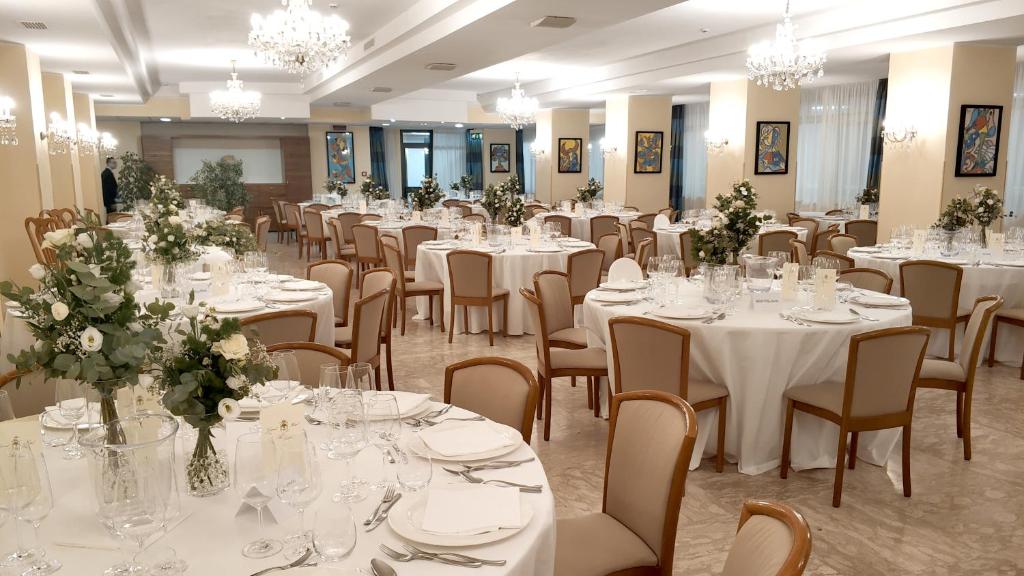 - une salle de banquet avec des tables blanches, des chaises et des fleurs dans l'établissement Grand Hotel Adriatico, à Montesilvano 37 autres photos