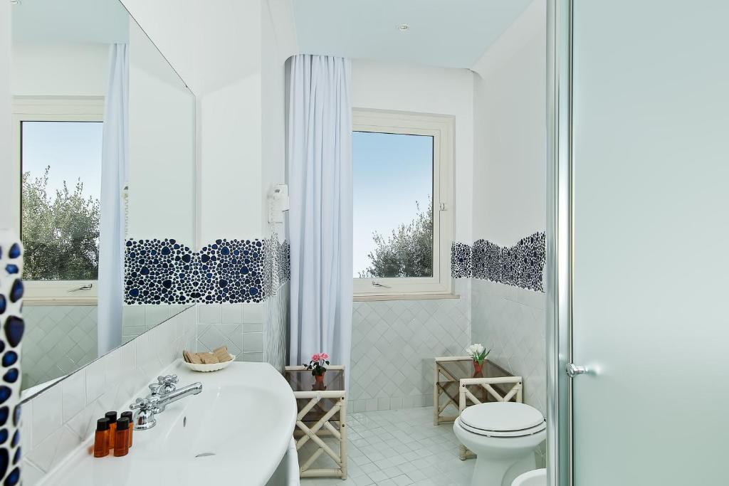 La salle de bains blanche est pourvue d'une baignoire et de toilettes. dans l'établissement Luxury Villas Positano, à Positano