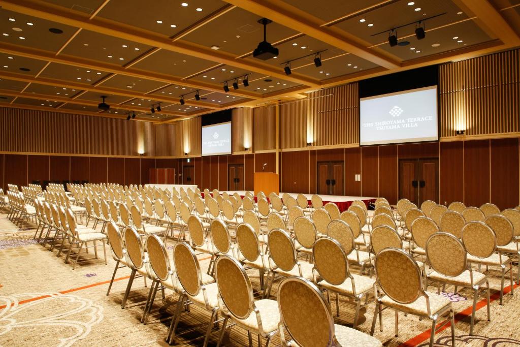 une salle de conférence vide avec des chaises et un écran dans l'établissement The Shiroyama Terrace Tsuyama Villa, à Tuyama 37 autres photos