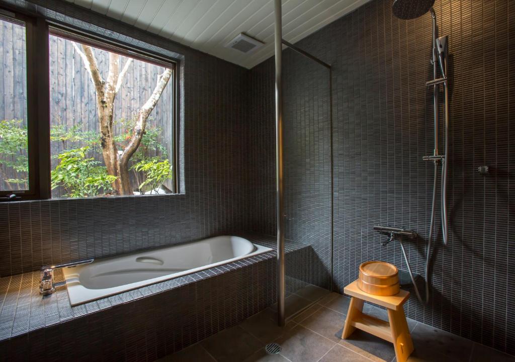 une salle de bain avec une baignoire et une fenêtre dans l'établissement Asan Kotonami, à Manno