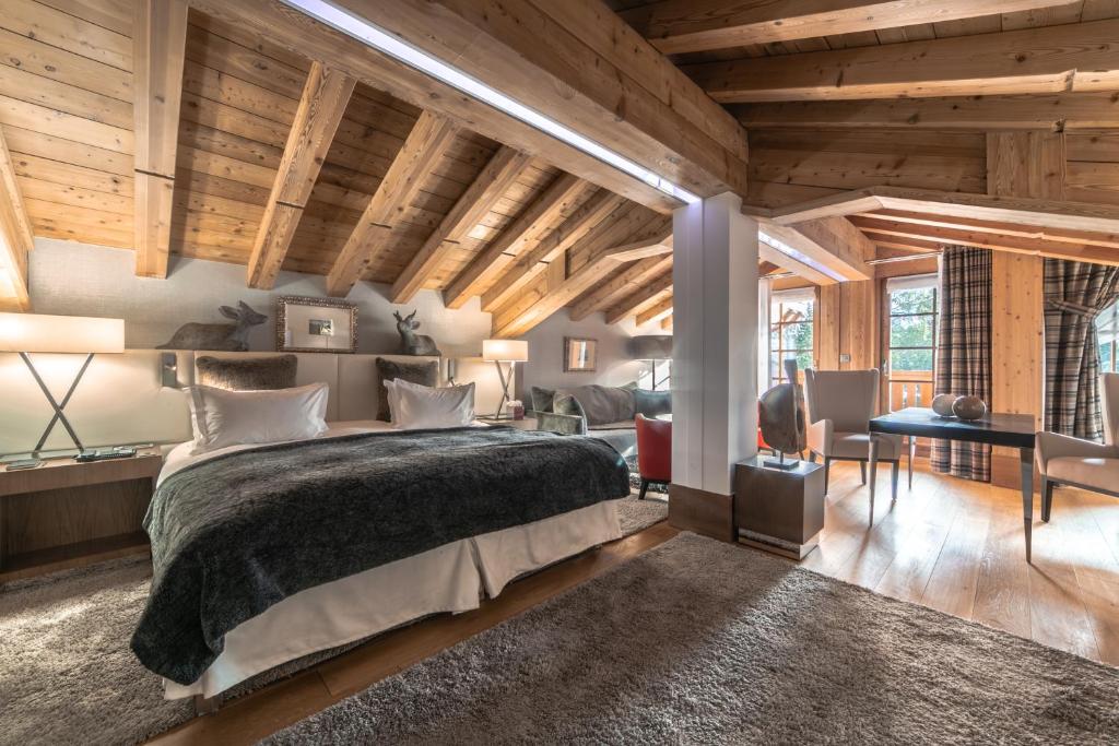 une chambre avec un grand lit et un bureau dans l'établissement Le Strato, à Courchevel