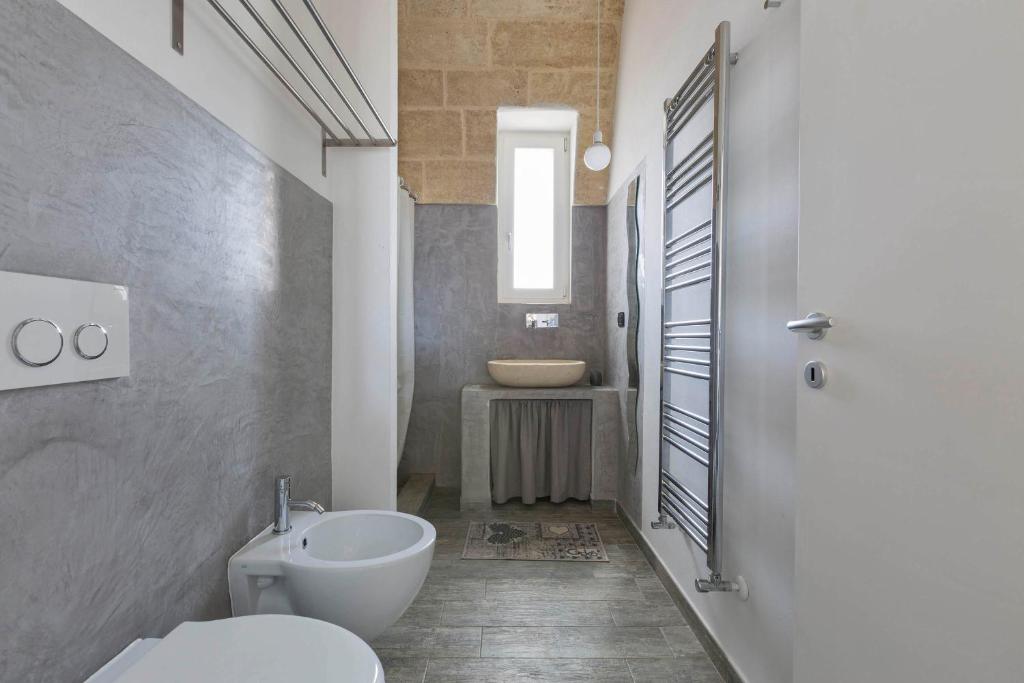 une salle de bain avec des toilettes blanches et un lavabo dans l'établissement Villa Toffi by Perle di Puglia, à Acquarica del Capo 20 autres photos