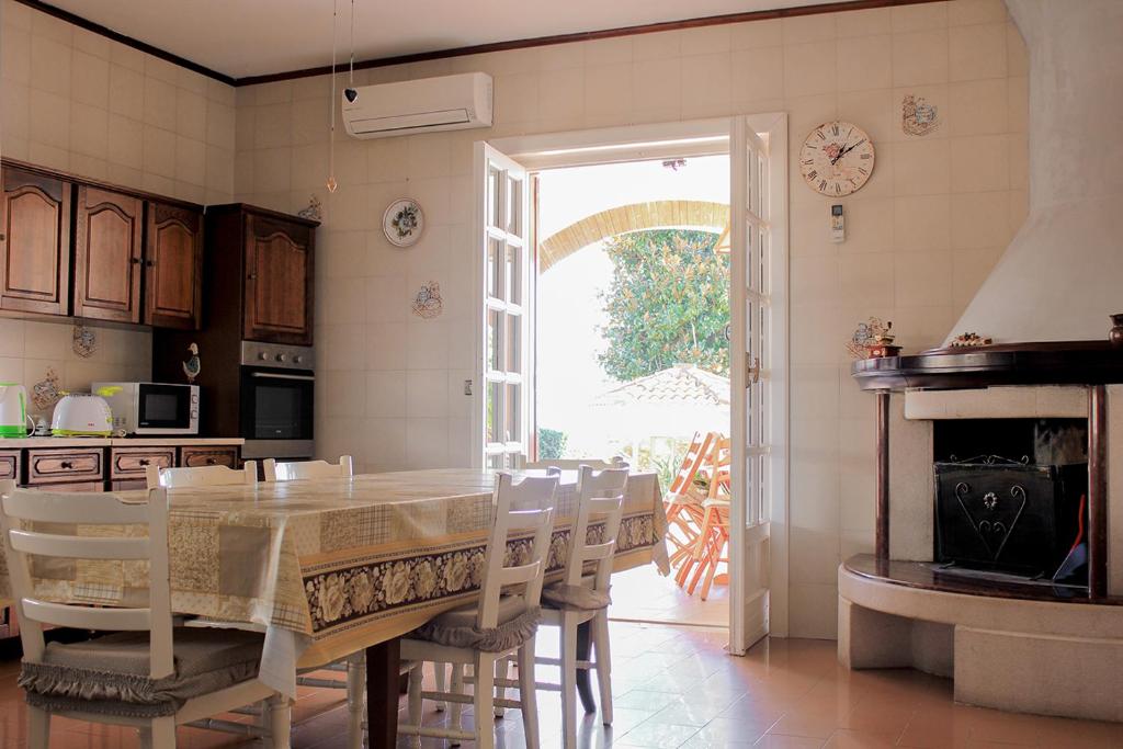 une cuisine avec une table et des chaises ainsi qu'une cheminée dans l'établissement La Villa dei Limoni - Villa Panoramic with Pool, à Formia