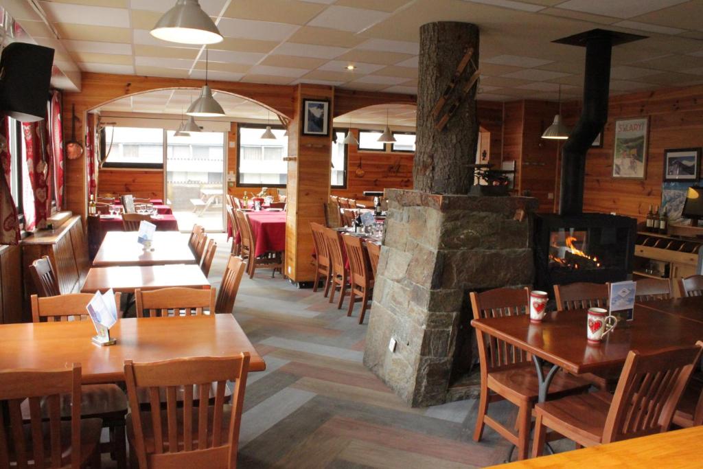 un restaurant avec des tables et des chaises et une cheminée dans l'établissement Ô CHALET 1700 chalet FFS, à Saint-Lary-Soulan