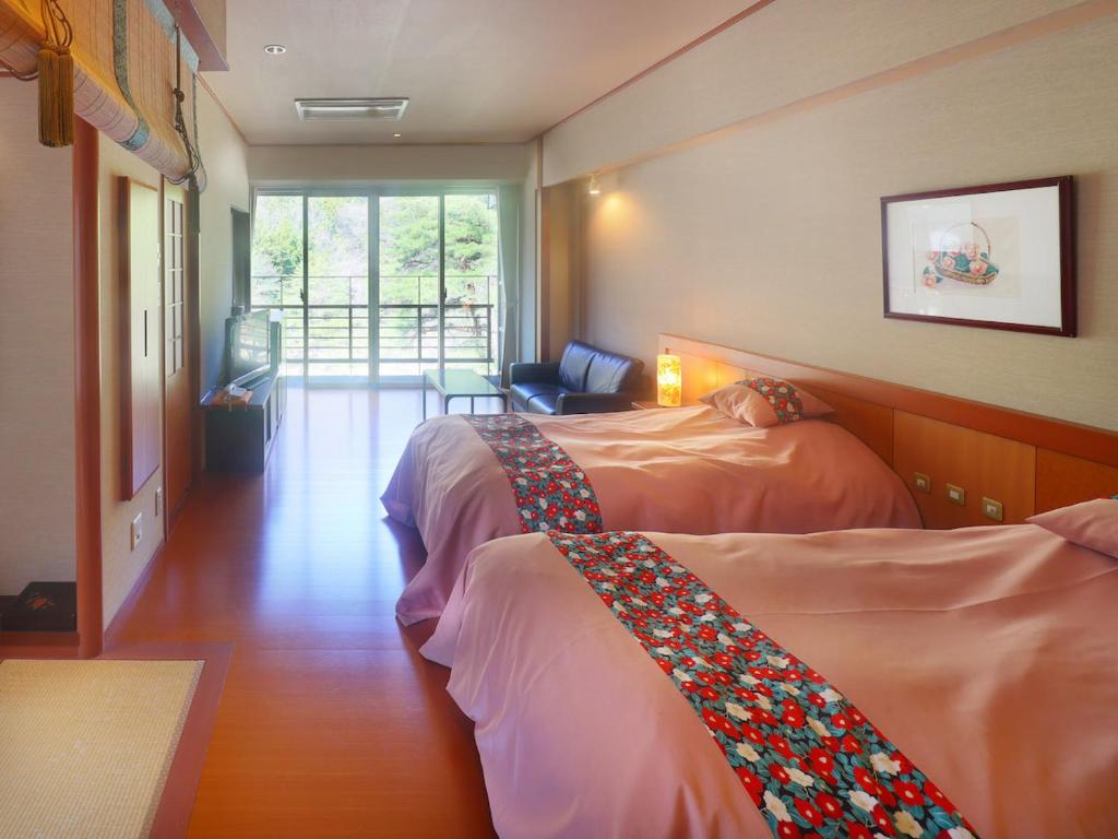 une chambre d'hôtel avec deux lits et un canapé dans l'établissement Kinugawa Onsen Hana no Yado Matsuya, à Nikkō