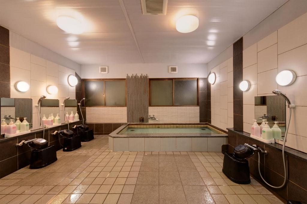 La salle de bains est pourvue d'une baignoire au milieu. dans l'établissement Hotel Oumiya, à Kyoto