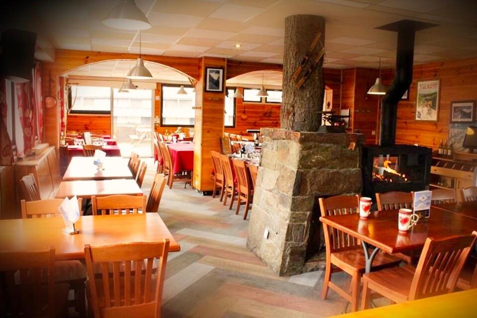 un restaurant avec des tables et des chaises et une cheminée dans l'établissement Ô CHALET 1700 chalet FFS, à Saint-Lary-Soulan