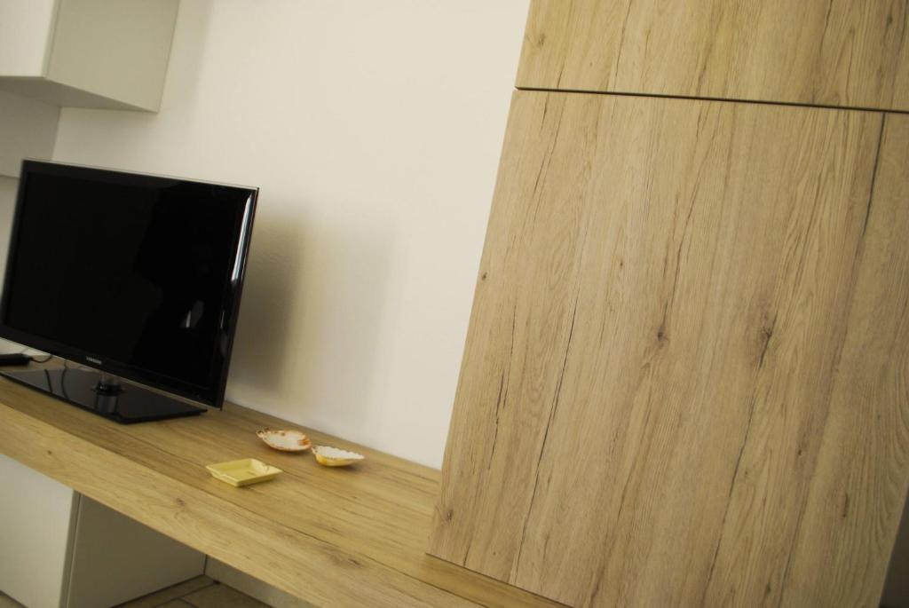 une télévision assise au-dessus d'un comptoir en bois dans l'établissement Villa Ada - Theater Home, à Tignale