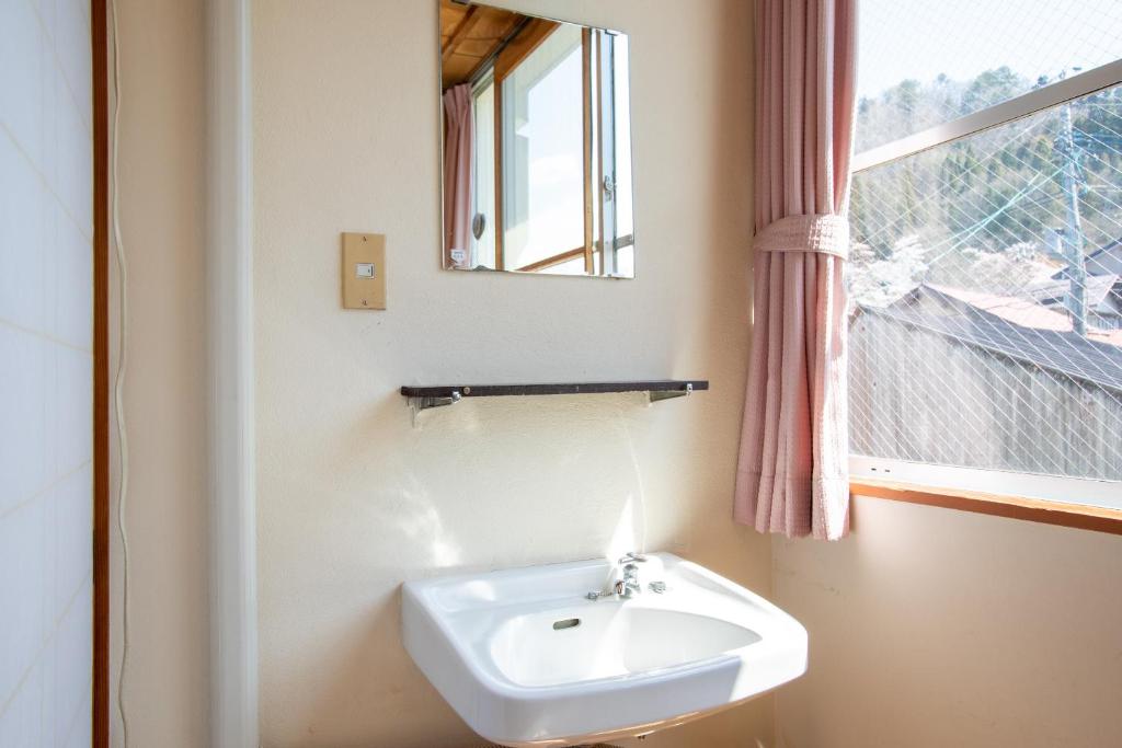 une salle de bain avec un lavabo et une fenêtre dans l'établissement Tabist Hana Hotel Takinoya Aizu-Yanaizu, à Yanaizu