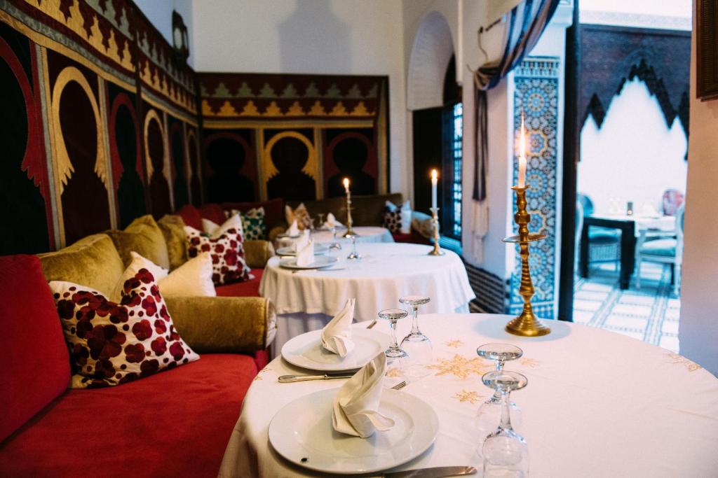 - un restaurant avec 2 tables et des verres à vin dans l'établissement Riad Maison Bleue and Spa, à Fès