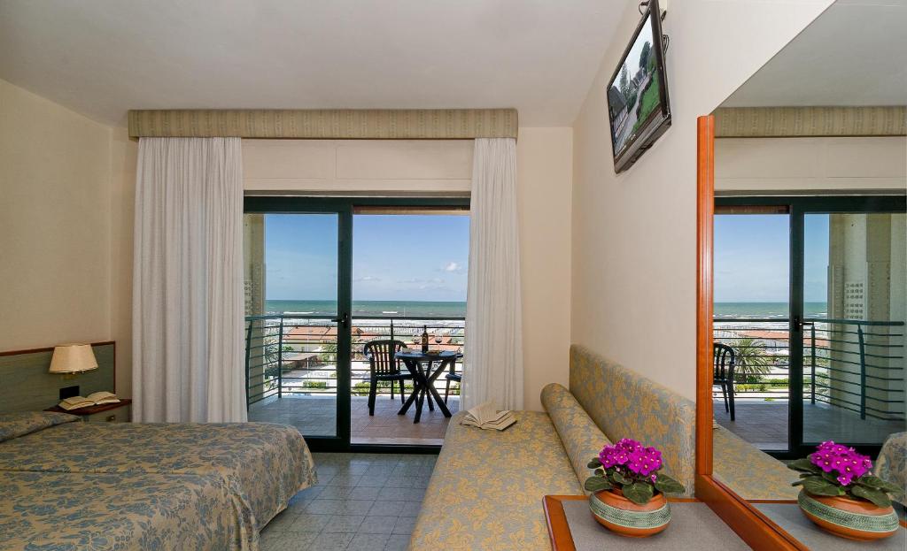 une chambre d'hôtel avec un lit et une vue sur l'océan dans l'établissement Hotel Paris, à Lido di Camaiore