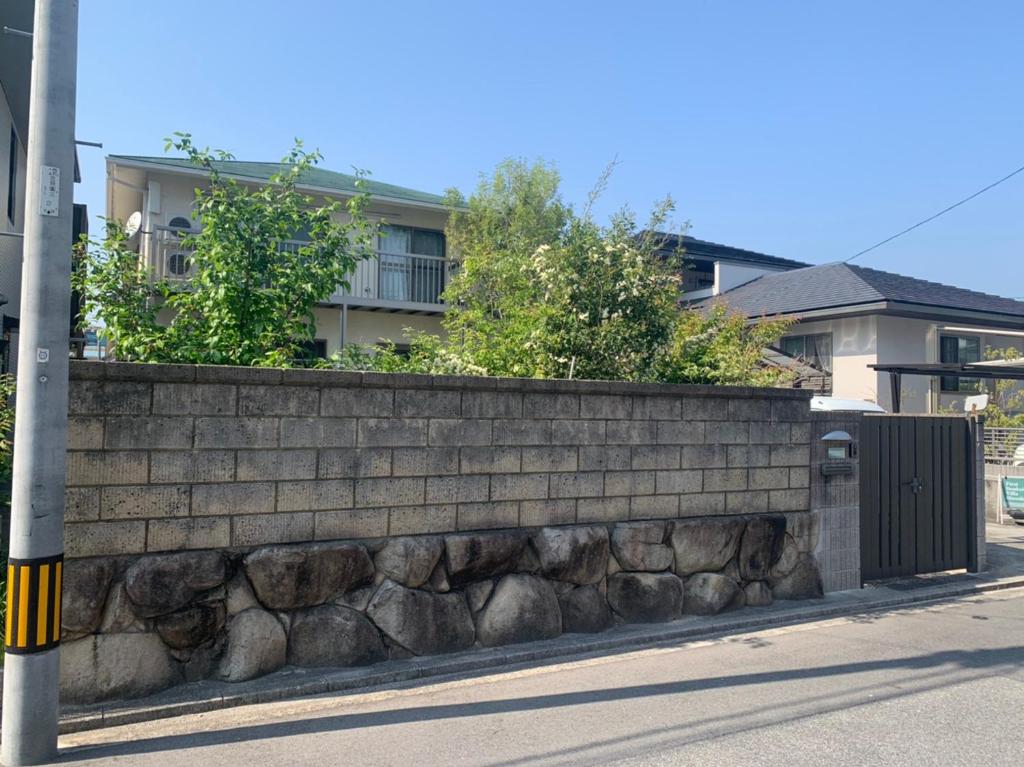 un mur de retenue en pierre avec des plantes au-dessus dans l'établissement Itsukaichi First Villa Hiroshima, à Hiroshima