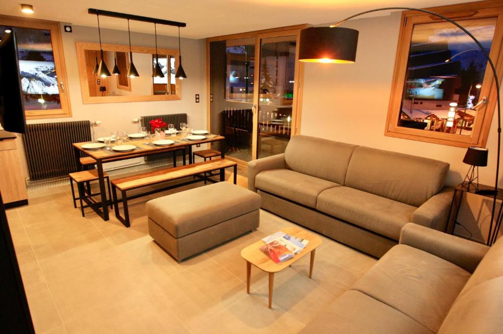 un salon avec un canapé et une table dans l'établissement L'Écrin Alpin - somptueux 4 pièces NEUF cœur station, à Les Deux Alpes
