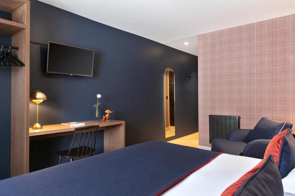 une chambre avec un lit, un bureau et une télévision dans l'établissement Hôtel Marielle, à Val Thorens