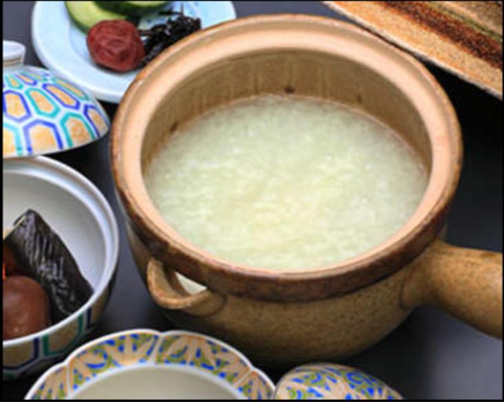 un bol de lait assis sur une table à côté des assiettes dans l'établissement Ryokan Adumaya, à Hongu