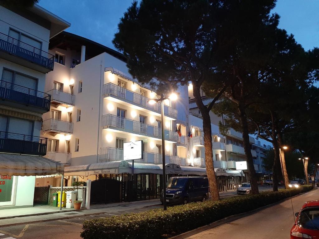 Un bâtiment blanc avec des lumières sur son côté dans l'établissement Hotel Venezia, à Caorle