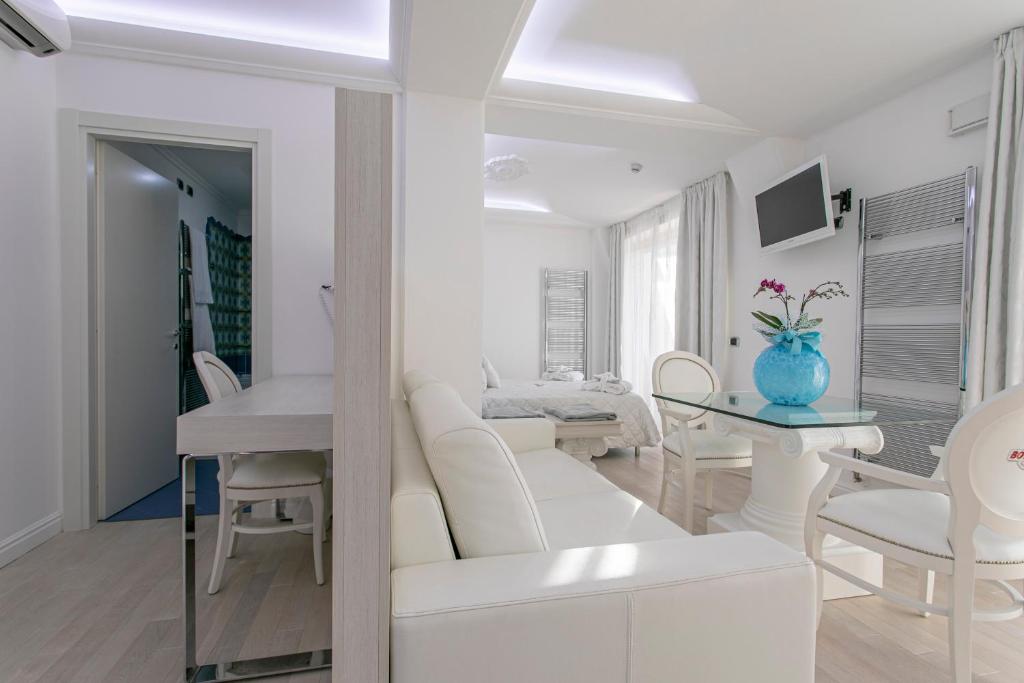 un salon blanc avec un canapé blanc et une table dans l'établissement Boutique Hotel Paradiso Bovelacci, à Milano Marittima