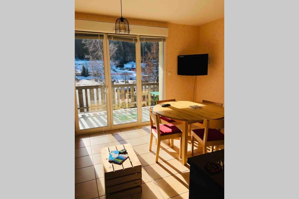 une salle à manger avec une table et une fenêtre dans l'établissement La perle du Grand Haut, à Gérardmer