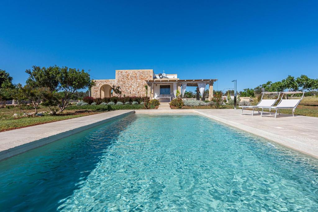 une piscine devant une maison dans l'établissement Leukos, dimora di charme, à Salve