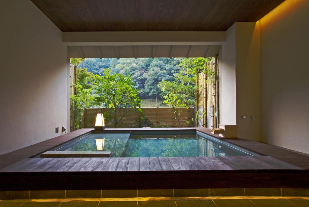 - une piscine dans une maison avec une grande fenêtre dans l'établissement Kawayu Onsen Fujiya, à Hongu