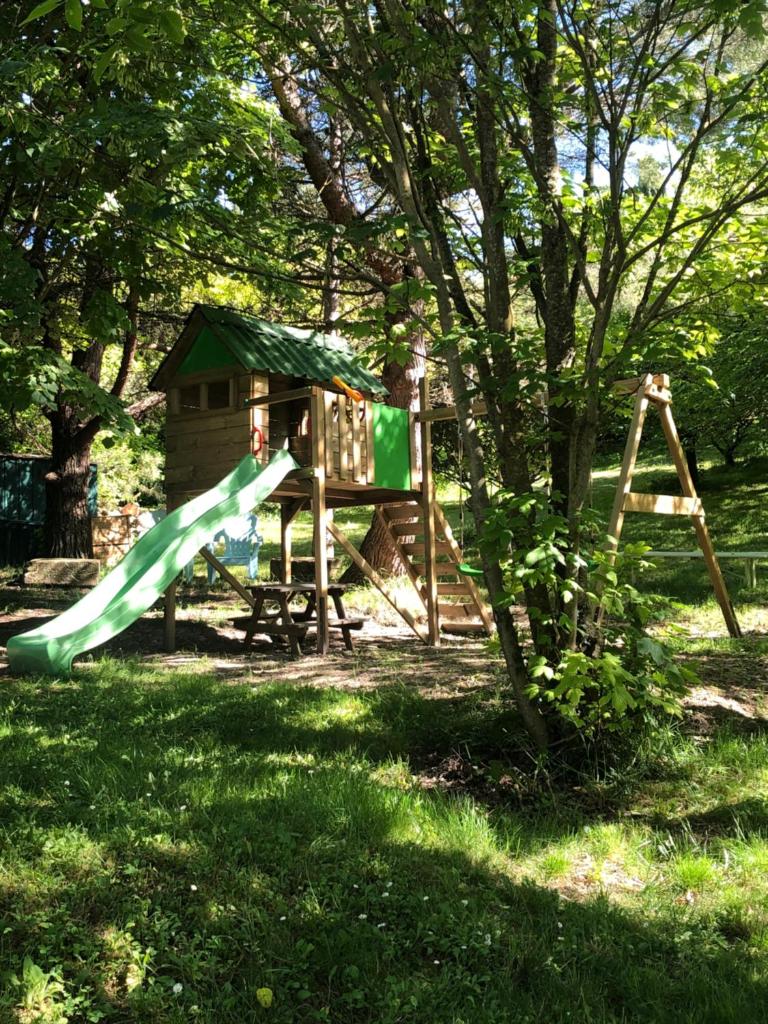 une aire de jeux avec toboggan et arbre dans l'établissement Gîte Au Coeur Du Pays Cathare, à Fanjeaux