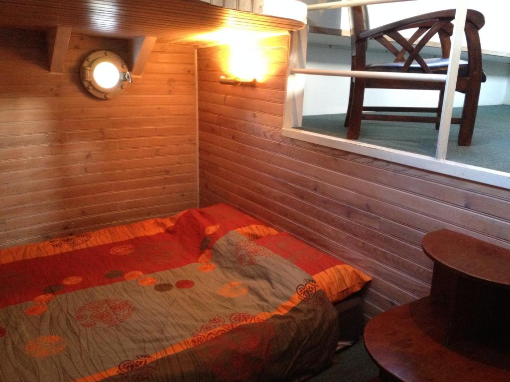 une petite pièce avec un lit et une fenêtre dans l'établissement Boat For Guest, à Issy-les-Moulineaux