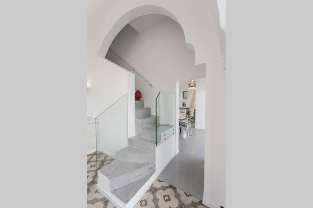 un couloir blanc avec des escaliers et une arche dans l'établissement Villa Fontana, à Francavilla Fontana