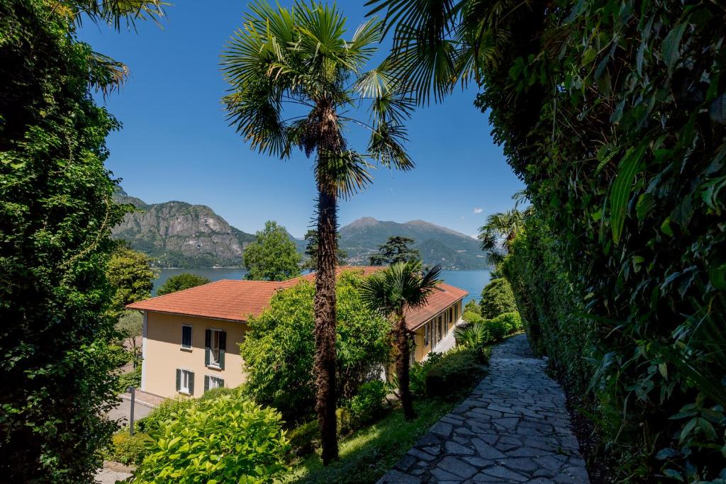 un palmier sur un chemin à côté d'un bâtiment dans l'établissement Residence L'Ulivo, à Bellagio