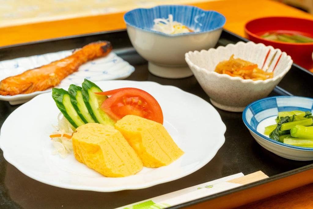 - un plateau avec une plaque blanche de nourriture et de légumes dans l'établissement Tabist Watanabe Chiba Ichinomiya, à Chosei