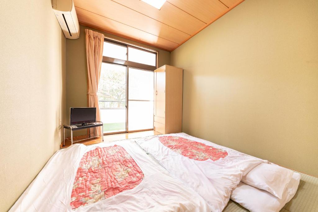 une chambre avec un grand lit et une fenêtre dans l'établissement Tabist Watanabe Chiba Ichinomiya, à Chosei