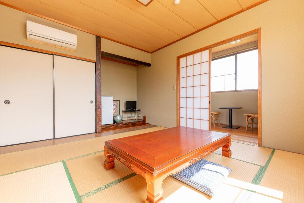 Cette chambre comprend une table en bois. dans l'établissement Tabist Watanabe Chiba Ichinomiya, à Chosei